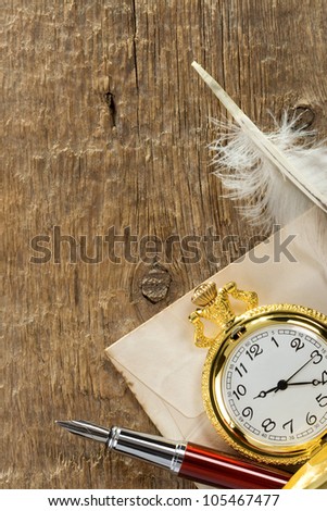 ink pen and watch on wooden background