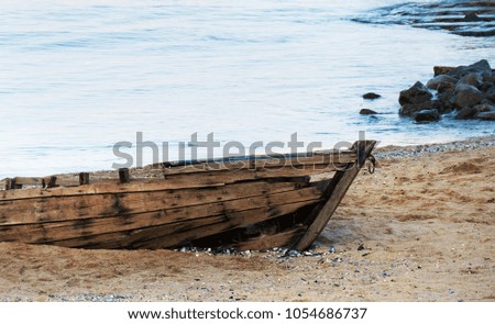 Old fishing boat on a coastline of the sea in sunset time