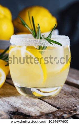 Lemon cocktail on dark rustic background, close-up. Refreshing alcoholic yellow cocktail drink.