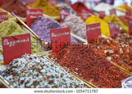 Colored spices in the eastern market. Texture, close-up. Translation of inscriptions on price tags: rainbow, scarlet