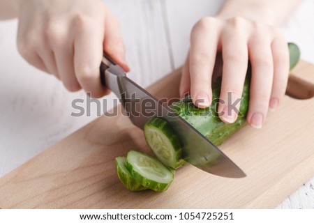 Cutting raw green cucumber