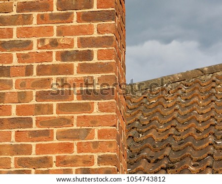 Brickwork Chimney Against Tiled Roof With Grey Sky In Background - Image