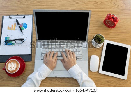 Top view female hands working on modern laptop. Office desktop on wooden background
