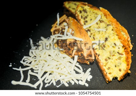 home baked banana bread with grated cheese against a black background