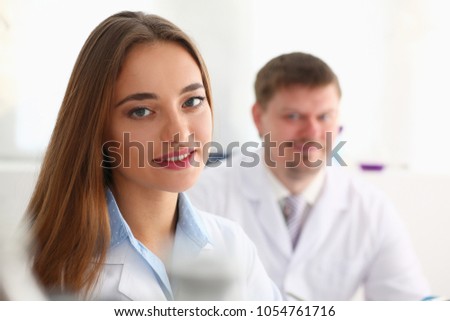 Smiling beautiful technician woman portrait and sample bottle with poison fluid. Medical worker in uniform use reagent tube for virus infection exam or biological toxic reaction drug creation