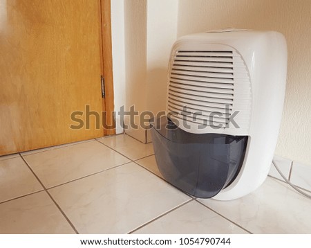 dehumidifier  in the room on the floor white red plastic
