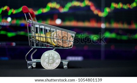 The digital currency coins in the shopping cart with trading graph background