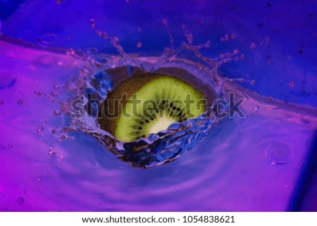Falling kiwi  fruit into the water with a beautiful splash.