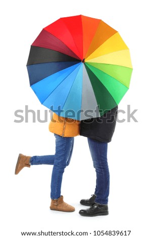 Young romantic couple with colorful umbrella on white background