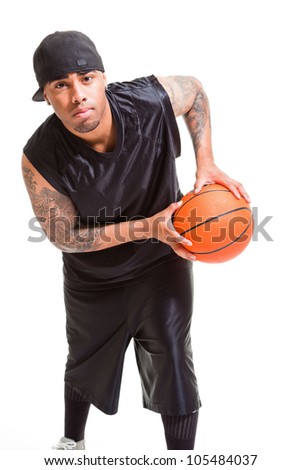 Studio portrait of basketball player wearing black cap standing and holding ball isolated on white.