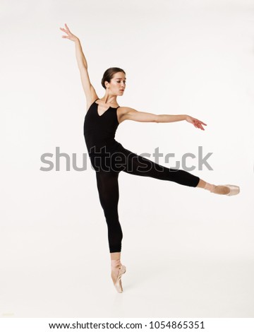 Beautiful ballerina posing in a white studio. Ballet dancer on white background. Ballerina in black tights