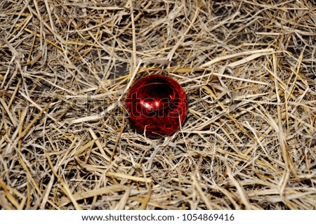 Red Christmas Tree bauble on hay