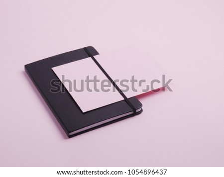 Composition of black and pink stationery such as notebook and paper card isolated on light pink background. Flat lay. Copy space. 