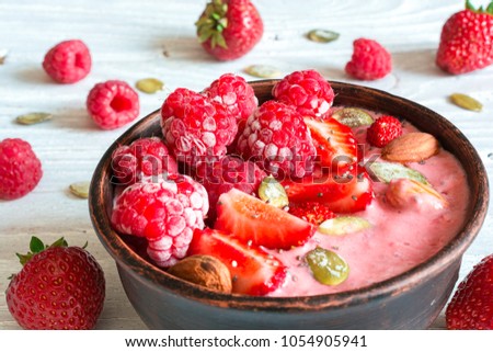 smoothie berry bowl with strawberry, raspberry, nuts and seeds for healthy breakfast. close up