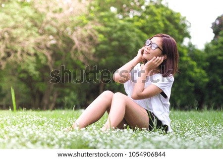 Young girl listening to music in the park