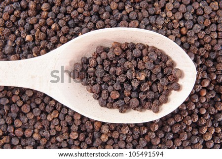 black pepper on wooden spoon