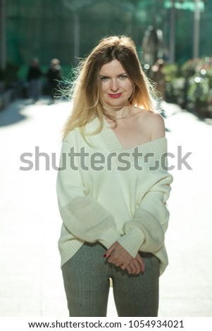 beautiful woman in a sweater walking around the city