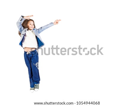 Image of excited emotional long-haired boy preschooler jumping isolated over white background wall pointing to copyspace.