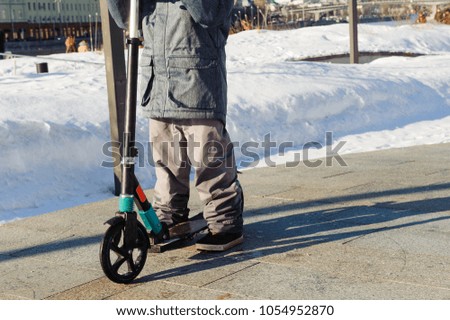 A boy is riding a scooter in a park in Moscow