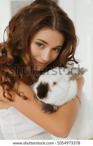 Young beautiful girl hugging a white rabbit. Easter