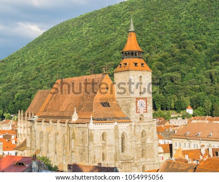 Famous medieval Black Church built in gothic style with Tampa mountain in the background and Brasov historic old town, Transylvania, Romania, Eastern Europe. Landmark building in the city center. 