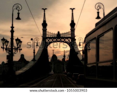 Liberty Bridge in Budapest, Hungary at sunset with silhouettes. tram passing by. old  landmark steel bridge. tourist attractions. popular European travel destination. evening sky. strong contrast