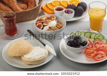 Turkish breakfast with cream cheese, vegetables, granola, fruits, and tea