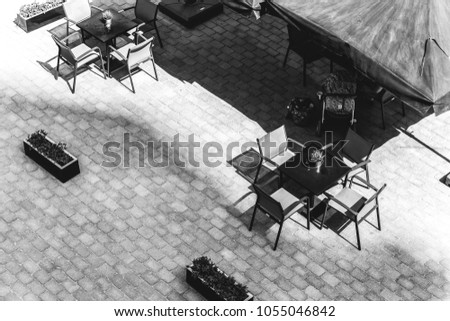 table and chairs in an outdoor cafe. Black and white photography. View from above
