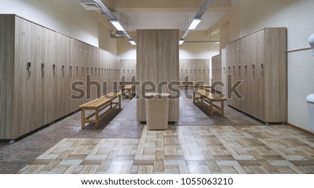 Locker room with wood benches and wooden lockers in the gym