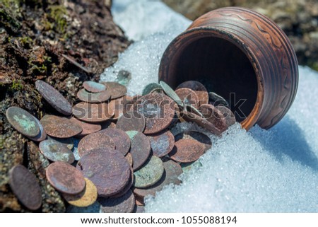 Antique rusty coins in an ancient pottery jug. Old Polish and Austrian money. The treasure of the 19 century. Royalty-Free Stock Photo #1055088194