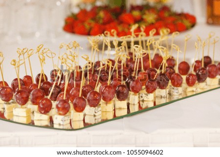 Rows of tasty mini canapes with brie cheese and grapes.Canape with cheese and grape