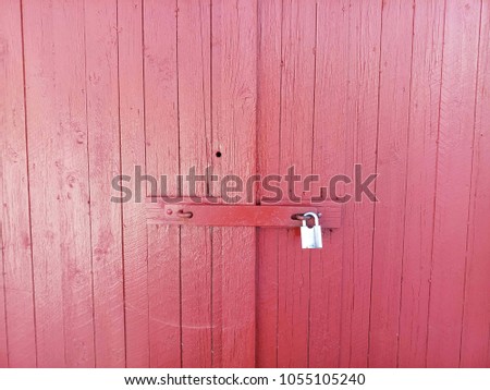 picture of a metal lock on a wooden red door