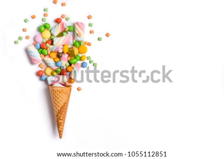 Ice cream cone flat lay image with colorful candy packing into the cone. Royalty-Free Stock Photo #1055112851