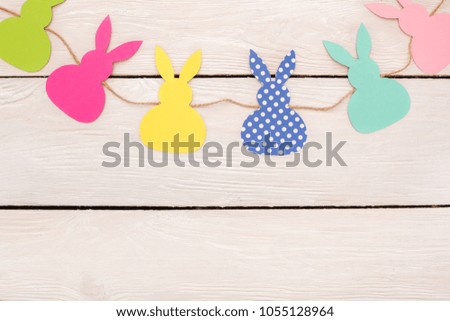 Easter traditional objects isolated on wooden background paper rabbits