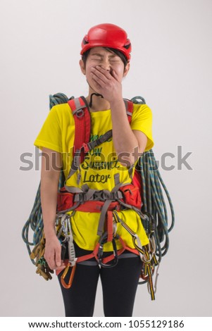 a young woman wearing in safety harness with climber equipment and ,rope,helmet