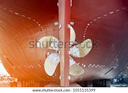 propeller closeup of container ship in floating dry dock of shipyard  Royalty-Free Stock Photo #1055135399