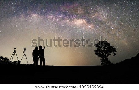 Couple photographer standing and looking for the milky way and stars on the sky at night.silhouette style.this picture may have some noise.
