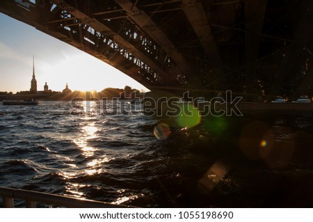 Silhouette of Peter and Paul Fortress in the sunset. View from under the bridge on Neva river. St. Petersburg, Russia