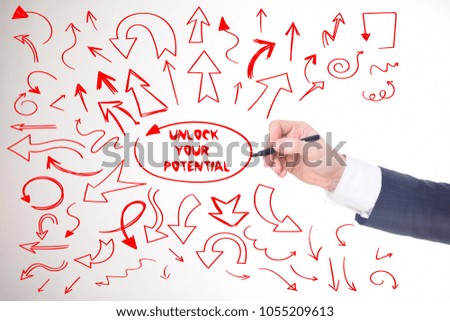 The businessman writes a red marker inscription:UNLOCK YOUR POTENTIAL