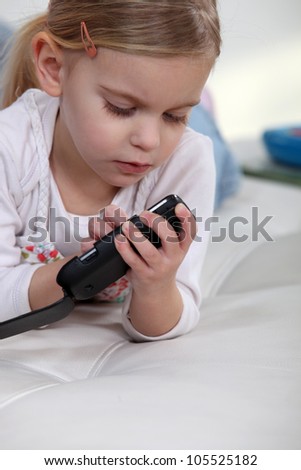 Little girl playing with mobile telephone