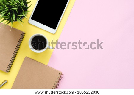 Office desk working space - Flat lay top view photo of working space with blank mock up tablet, coffee cup and notebook on pastel background. Pastel pink yellow color copy space working desk concept.