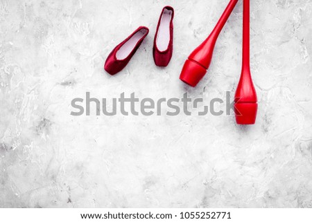 Beauty sport for girls concept. Maces for rhythmic gymnastics and ballet shoes on grey background top view copy space