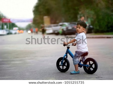 Soft focus at Asian boy riding the bicycle on the road and looking back to the camera/ blur background with street and finish line in the picture / Concept of never give up , Cheerful and competition