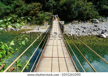 Suspension bridge, Crossing the river, ferriage in the woods Royalty-Free Stock Photo #1055261090