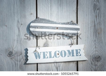 Wooden welcome sign in rustic style hanging on plank door