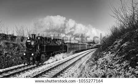 Beautiful old steam train with wagons running on rails at sunset. Excursions for children and parents on festive special days. Czech Republic Europe.
Black and white photography.