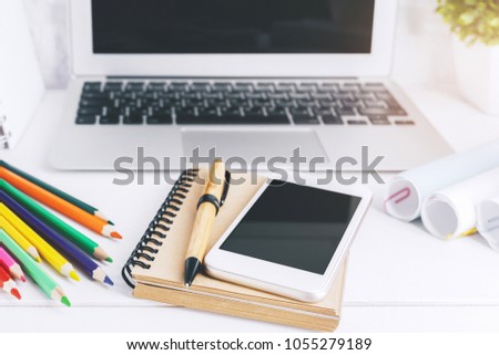 Mix of office supplies, laptop computer and mobile phone on modern white workplace with other items. Mock up 