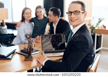Family lawyer is sitting at table with divorcing family at background. Registration of guardianship of little girl. Family in office of family lawyer. Royalty-Free Stock Photo #1055292233