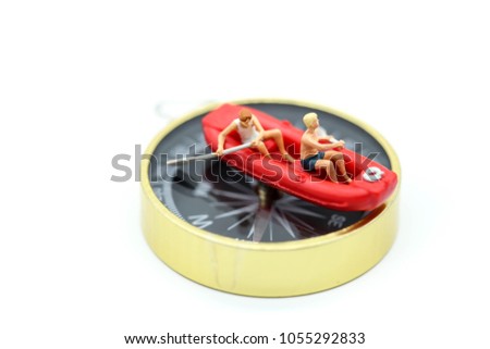 Miniature people : on paddle boat with compass,travel business concept.