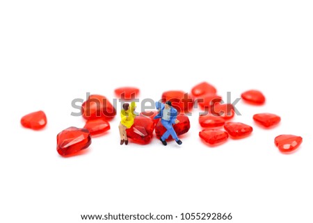 Miniature people : Couple of love sitting with red hearts ,Lover and valentine concept.